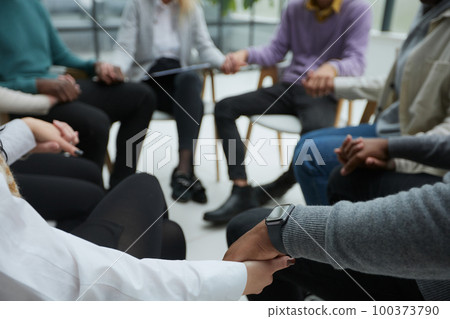 close-up of a business team sitting holding hands close-up of a business team sitting holding hands 100373790
