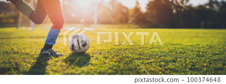 Child playing football on the field with gates. Child playing football on the field with gates. 100374648