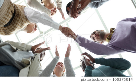 Closeup Business partners shaking hands, celebrating business success in modern office with high ceiling. 100375014