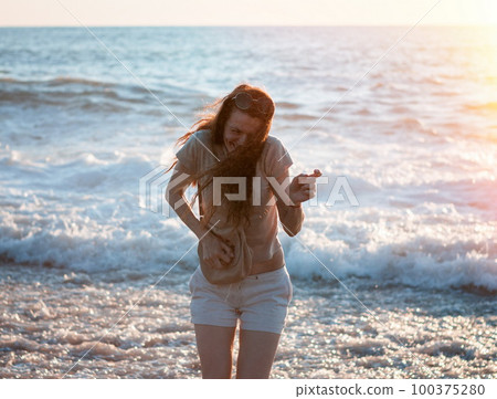 Brunette woman at the sea on sunset Brunette woman at the sea on sunset 100375280