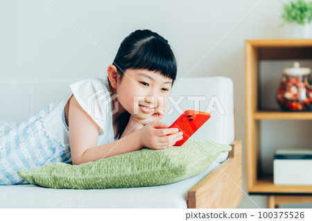 小學生在客廳裡看智能手機 100375526