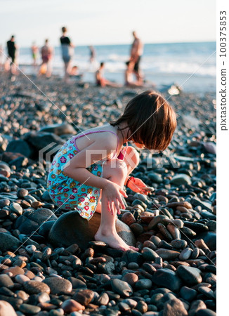 Little girl playing at the beach 100375853