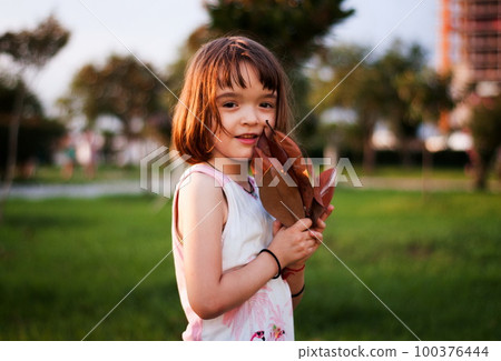 Little girl having fun outdoors in sunset 100376444