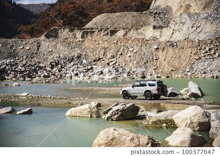 White offroader car in adventure of rocky mountains through river and lake White offroader car in adventure of rocky mountains through river and lake 100377647