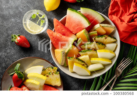 Fruits assortment platter antipasti, watermelon, pineapple, melon and strawberries. Dark background 100380568
