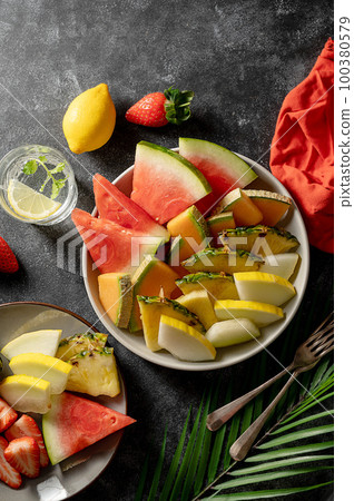 Fruits assortment platter antipasti, watermelon, pineapple, melon and strawberries. Dark background 100380579