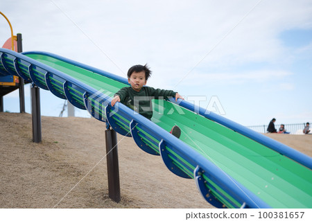 Boys playing on a slide 100381657