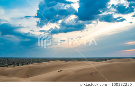 Bright blue cloudy sky over the yellow desert of Kyzylkum Kazakhstan. Rainy weather in the desert. Beautiful landscape of the desert of Central Asia 100382230