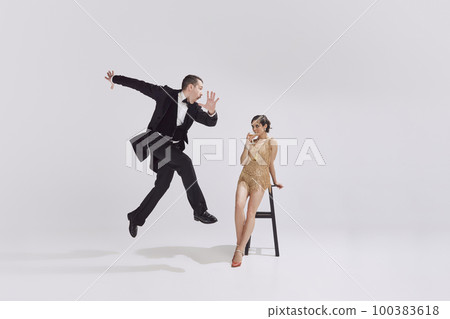 Retro man and adorable woman in vintage evening festive outfits dancing retro ballroom dance. Concept of ove and music, eras comparison 100383618