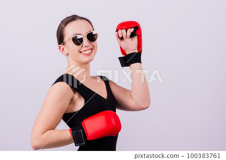 Seductive female boxer with athletic beautiful figure in black swimsuit gloves on gray background Seductive female boxer with athletic beautiful figure in black swimsuit gloves on gray background 100383761