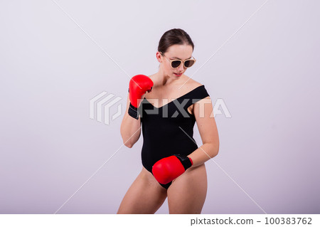 Seductive female boxer with athletic beautiful figure in black swimsuit gloves on gray background Seductive female boxer with athletic beautiful figure in black swimsuit gloves on gray background 100383762