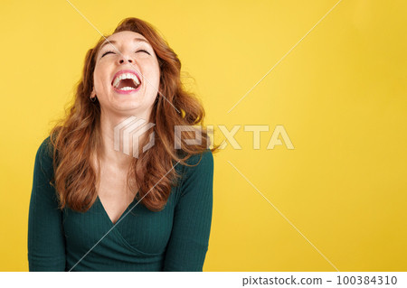 Happy redheaded woman laughing and looking up Happy redheaded woman laughing and looking up 100384310