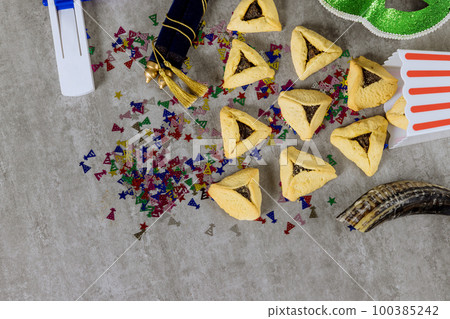 Jewish holidays religious Purim festival with hamantaschen cookies shofar noisemaker tallit carnival masks as symbols of celebration 100385242