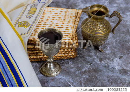 During Passover Jews eat kosher unleavened matzah bread and drink kosher kiddush wine for Pesach 100385253