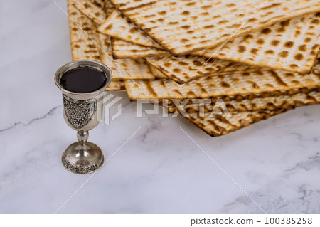 During Pesach, kosher kiddush cup wine is served with unleavened matzah bread 100385258