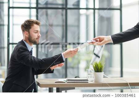 Close Up Of Businessman Taking Folders From Hand 100385461