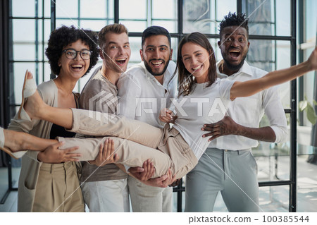 Business team throwing his colleague in office Business team throwing his colleague in office 100385544