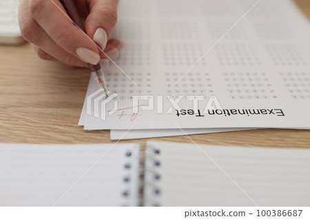 Hand with pen on examination test paper with excellent mark close up. 100386687