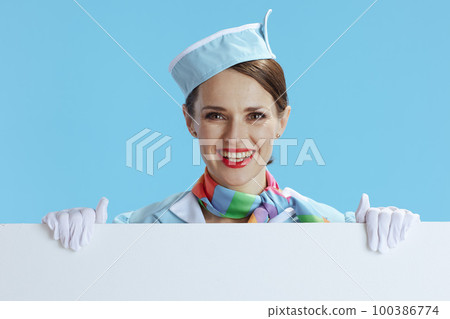 smiling elegant stewardess woman on blue showing blank board 100386774