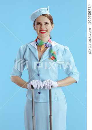 smiling flight attendant woman on blue looking up at copy space smiling flight attendant woman on blue looking up at copy space 100386784