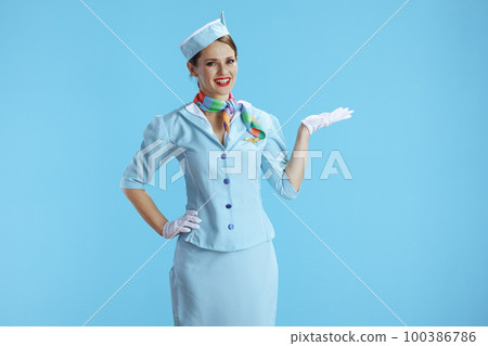 happy stylish air hostess woman on blue presenting something happy stylish air hostess woman on blue presenting something 100386786