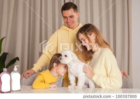 Cute family with little white dog on the table, abstract plastic bottles 100387800