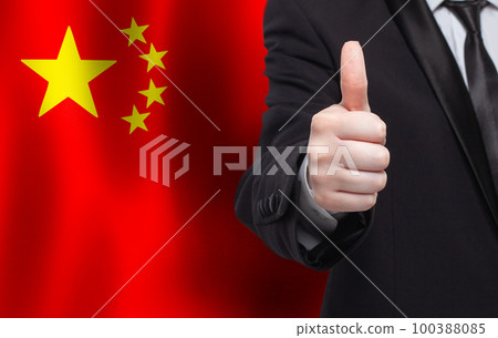 Chinese concept. Businessman showing thumb up on the background of flag of China Chinese concept. Businessman showing thumb up on the background of flag of China 100388085