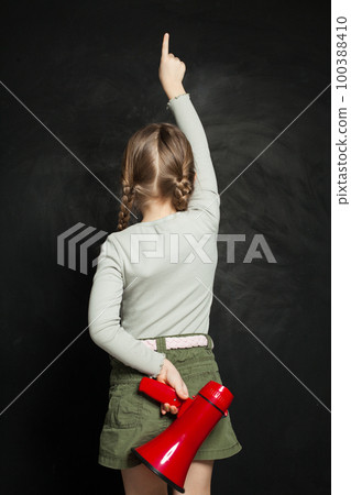 Cute little girl holding megaphone against a blackboard. Kid with loudspeaker Cute little girl holding megaphone against a blackboard. Kid with loudspeaker 100388410
