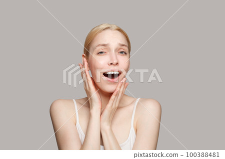Happy surprised blonde woman isolated on grey background. Beauty, cosmetics, skincare, glamour Happy surprised blonde woman isolated on grey background. Beauty, cosmetics, skincare, glamour 100388481