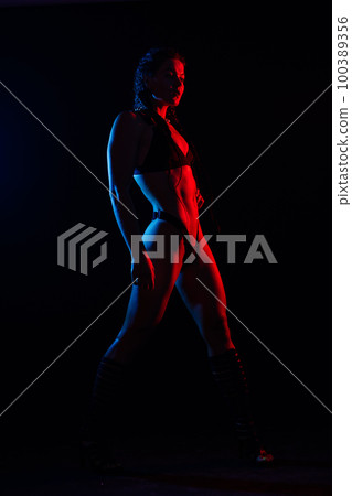 Young woman in underwear is in the studio with neon lights. Young woman in underwear is in the studio with neon lights. 100389356