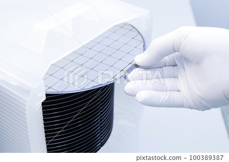 Gloved Hand Holding a Silicon Wafer in plastic holder box used in electronics for the fabrication of integrated circuits. Silicon wafer inspection. Gloved Hand Holding a Silicon Wafer in plastic holder box used in electronics for the fabrication of integrated circuits. Silicon wafer inspection. 100389387