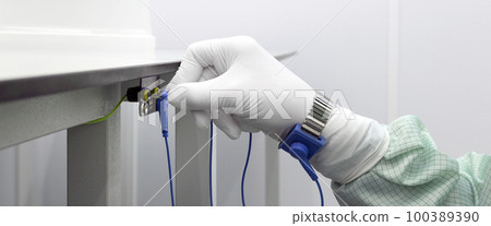 Bracelet on the hand of a man wearing ESD cloth and glove static resistance ESD bracelet or ground equipment, anti-static, used to safely ground is working. Semiconductor manufacturing.Banner Bracelet on the hand of a man wearing ESD cloth and glove static resistance ESD bracelet or ground equipment, anti-static, used to safely ground is working. Semiconductor manufacturing.Banner 100389390