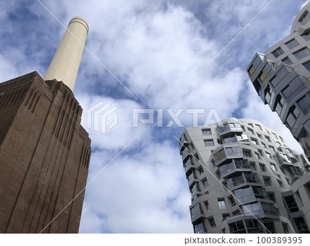 Battersea Power Station, London, UK. Old fashioned chimneys against modern new build architecture against one other, building city. Battersea Power Station, London, UK. Old fashioned chimneys against modern new build architecture against one other, building city. 100389395