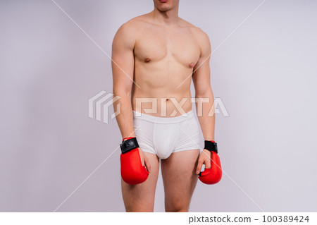 Bodybuilders boxing gloves on white background and white pants athlete model Bodybuilders boxing gloves on white background and white pants athlete model 100389424