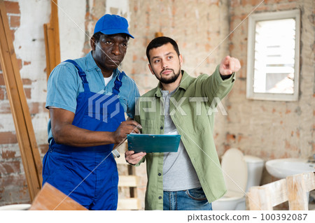 Two men talking on indoor construction site 100392087