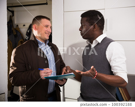 Smiling man participating in survey at home 100392188