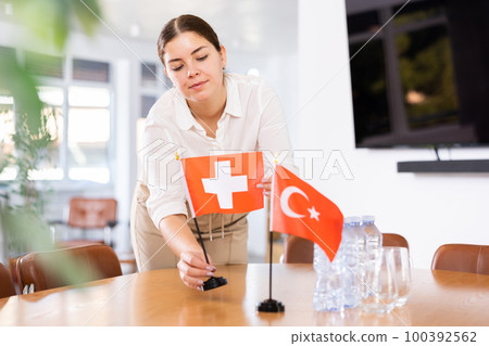 female assistant prepares conference room for diplomats of Switzerland and Turkey 100392562