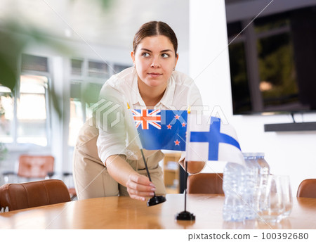 female assistant prepares conference room for diplomats of Finland and Australia female assistant prepares conference room for diplomats of Finland and Australia 100392680