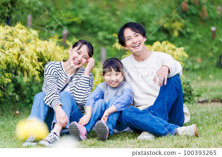 親密的家人坐在公園的草地上 100393265