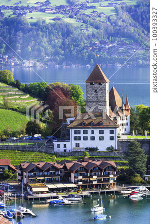 Switzerland  travel. Scenic lake Thun and the Spiez village with its famous medieval castle and old town in the alps in Canton Bern 100393327