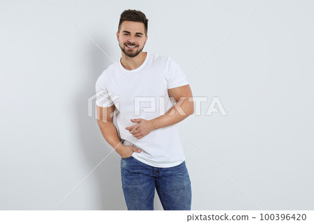 Young man in stylish jeans on light background 100396420