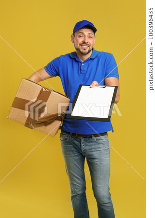 Emotional courier with damaged cardboard box and clipboard on yellow background Emotional courier with damaged cardboard box and clipboard on yellow background 100396435