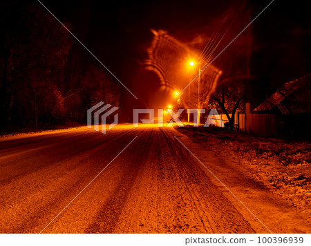Night winter snowy road for cars in the light of lanterns. 100396939