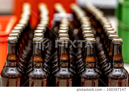 dewy bottles of beer in a row in a warehouse ready for export dewy bottles of beer in a row in a warehouse ready for export 100397147