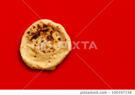 Egyptian bread Aish Baladi. Fresh bread lies on the red table Egyptian bread Aish Baladi. Fresh bread lies on the red table 100397156