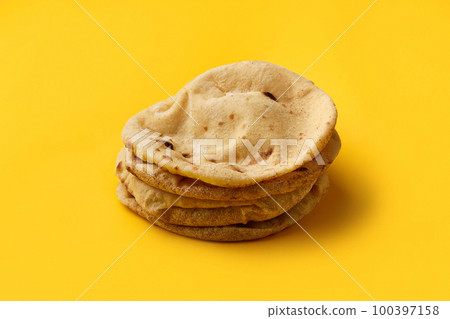 Egyptian bread Aish Baladi on. A lot of fresh bread lies on the yellow table 100397158