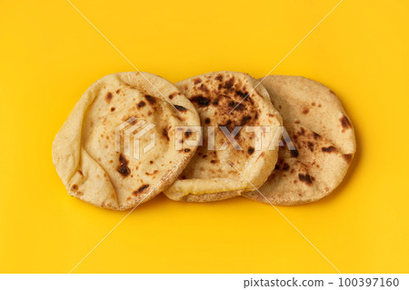 Egyptian bread Aish Baladi on. A lot of fresh bread lies on the yellow table 100397160