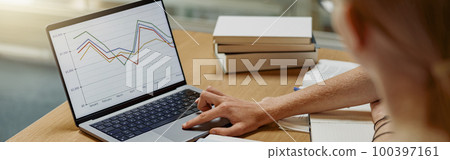 Students sit in the library and take notes while preparing for the exam 100397161