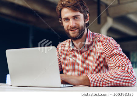 Portrait of young caucasian businessman using laptop computer at his workplace Portrait of young caucasian businessman using laptop computer at his workplace 100398385