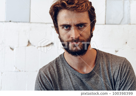 Pensive bearded man in shirt looking at camera 100398399